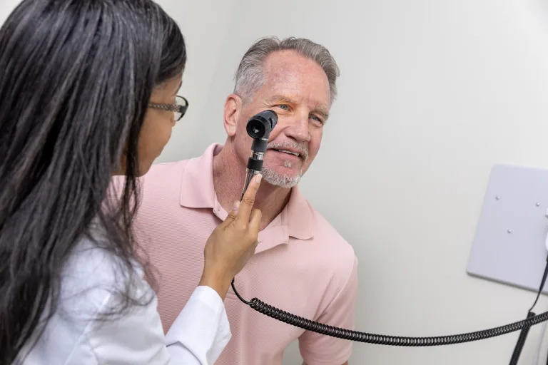 A male patient gets an eye exam at Community Health Northwest Florida.