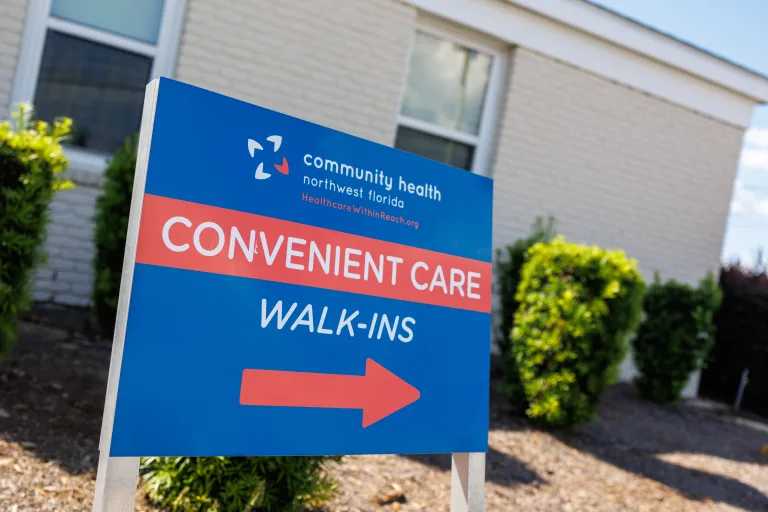 A sign pointing patients to the correct door at the Trinity Pediatrics location of Community Health Northwest Florida.