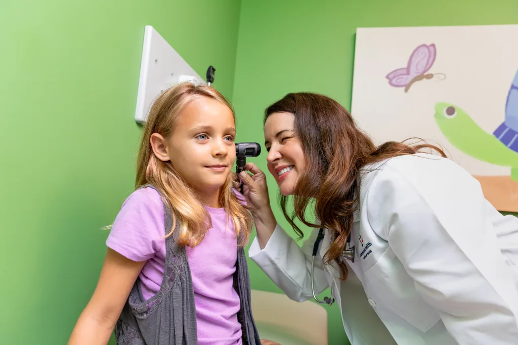 A young girl gets her ears checked by a Community Health Northwest Florida doctor.